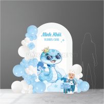 Phông cứng thôi nôi bé trai tông xanh dương pastel với linh vật rắn xanh đội vương miện.